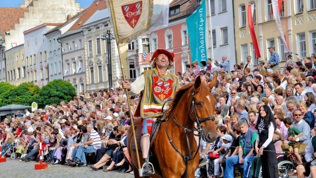 Mann mit Straubing Wappen auf Pferd während des Auszuges zum Gäubodenvolksfest